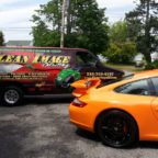 Orange Porsche 911 with Clean Image truck.