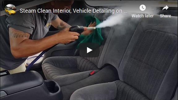 Steam cleaning car interior back seat.