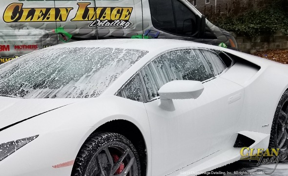 White Lamborghini in foam bath with Clean Image truck.